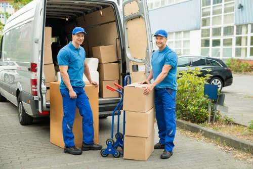 Team carrying furniture through a shared hallway during a Harrow flat move